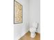 Stylish powder room with modern art, white toilet, and light hardwood flooring at 913 Echo Park Dr, Suwanee, GA 30024