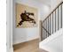 Hallway featuring modern art, hardwood floors, and stairs with black metal railings at 913 Echo Park Dr, Suwanee, GA 30024