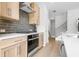 Kitchen with stainless steel appliances, white countertops, wood cabinets, and stylish tile backsplash at 913 Echo Park Dr, Suwanee, GA 30024