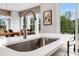 Bright kitchen island features a stainless steel faucet, deep sink, and views of nature at 913 Echo Park Dr, Suwanee, GA 30024