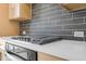 Modern kitchen details, including a gray tile backsplash and stainless steel stove top at 913 Echo Park Dr, Suwanee, GA 30024