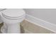 Close-up on a toilet with neutral tiles and white trim at 913 Echo Park Dr, Suwanee, GA 30024