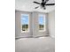 Bedroom with neutral walls, grey carpet, and two large windows at 923 Echo Park Dr, Suwanee, GA 30024