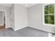 Bedroom with a large window, neutral walls, grey carpet, and white door at 923 Echo Park Dr, Suwanee, GA 30024