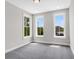 Bedroom featuring neutral walls, grey carpet, and three large windows at 923 Echo Park Dr, Suwanee, GA 30024