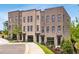 Charming townhome exterior featuring a brick facade, manicured landscaping, and a paved walkway at 923 Echo Park Dr, Suwanee, GA 30024