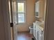 Bathroom with a window, toilet, and single sink vanity, providing essential amenities at 7472 Wood Ct, Lithonia, GA 30058