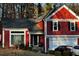 A vibrant red two-story home featuring a well-manicured lawn and two-car garage at 7472 Wood Ct, Lithonia, GA 30058