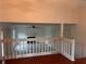 Upstairs living area showcasing a decorative railing, ceiling fan and views into the room below at 7472 Wood Ct, Lithonia, GA 30058