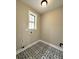 Bright laundry room with decorative tile floors and natural light from the window at 15 Stratford Way, Kingston, GA 30145