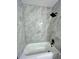 Clean bathroom featuring a bathtub and marble-tiled walls at 204 Apple Branch Dr, Woodstock, GA 30188
