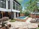 Backyard featuring a long swimming pool, surrounding stone deck, and lush landscaping at 220 Windsor Gate Ne Cv, Atlanta, GA 30342