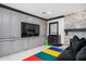 A Gathering room with gray cabinets, stone fireplace, TV, and colorful play mat at 220 Windsor Gate Ne Cv, Atlanta, GA 30342