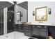 The luxurious bathroom features black herringbone tile and gold fixtures in a glass shower at 220 Windsor Gate Ne Cv, Atlanta, GA 30342