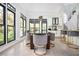 Elegant dining area featuring large windows, modern lighting, and stylish seating at 220 Windsor Gate Ne Cv, Atlanta, GA 30342