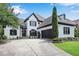Striking two-story home with arched windows, two-car garage, dark trim, and a well-manicured lawn at 220 Windsor Gate Ne Cv, Atlanta, GA 30342