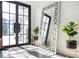 Bright foyer with grand mirror, tile flooring, and modern accents at 220 Windsor Gate Ne Cv, Atlanta, GA 30342