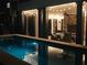 Backyard pool at night featuring ambient lighting and covered patio at 220 Windsor Gate Ne Cv, Atlanta, GA 30342