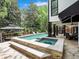 Backyard pool featuring an integrated spa and outdoor dining area with stone deck at 220 Windsor Gate Ne Cv, Atlanta, GA 30342