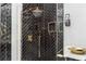 A luxurious glass shower with black herringbone tile and gold fixtures at 220 Windsor Gate Ne Cv, Atlanta, GA 30342