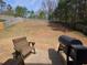 Large backyard with a retaining wall, grilling area, and wooded views at 106 Puckett Ct, Canton, GA 30115