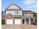 Charming two-story home featuring a brick facade, two-car garage, and covered porch area at 106 Puckett Ct, Canton, GA 30115