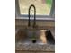 Close-up of a stainless steel kitchen sink with a granite countertop and subway tile backsplash at 106 Puckett Ct, Canton, GA 30115