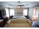 Spacious main bedroom featuring a tray ceiling, ceiling fan, and ensuite bathroom at 106 Puckett Ct, Canton, GA 30115
