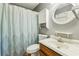 Traditional bathroom featuring a round mirror, patterned shower curtain, and wood-tone vanity at 1057 Falling Water Se Dr, Smyrna, GA 30080