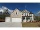 Charming stone two-story home featuring a three-car garage and landscaped front yard at 6969 Melody Dr, Buford, GA 30518
