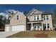 Attractive stone two-story home with a landscaped front yard, offering classic design elements at 6969 Melody Dr, Buford, GA 30518