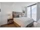 A cozy bedroom with a large window, stylish furniture, and wood flooring at 788 W Marietta Nw St # 403, Atlanta, GA 30318