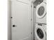 Convenient laundry area with a stacked washer and dryer, and a modern white door at 788 W Marietta Nw St # 403, Atlanta, GA 30318