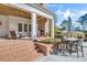 Covered back porch with brick fireplace, ceiling fan, and outdoor dining set perfect for relaxation and entertaining at 710 Cox Rd, Roswell, GA 30075