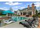 Expansive backyard featuring a stunning pool with sun shelves, a covered patio, and beautiful landscaping at 710 Cox Rd, Roswell, GA 30075