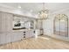 Basement bar with hardwood floors, cabinets, wine cooler and a decorative chandelier at 710 Cox Rd, Roswell, GA 30075