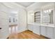 Bright bathroom with hardwood floors offers double sinks, storage, and access to outdoors at 710 Cox Rd, Roswell, GA 30075