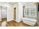 Spa-like bathroom features a freestanding tub, large window, and separate glass-enclosed shower at 710 Cox Rd, Roswell, GA 30075