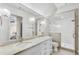 Bright bathroom boasts marble counters, double vanity, decorative fixtures, and glass enclosed shower at 710 Cox Rd, Roswell, GA 30075