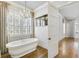Bright bathroom showcasing a modern soaking tub, shuttered windows, and access to a walk-in closet at 710 Cox Rd, Roswell, GA 30075