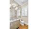 Elegant powder room features a decorative vanity, unique mirror wall, and natural light from the window at 710 Cox Rd, Roswell, GA 30075