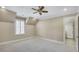 Spacious bedroom features a ceiling fan, neutral paint, carpet, and an en-suite bathroom visible through an open door at 710 Cox Rd, Roswell, GA 30075
