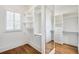 Walk-in closet featuring custom shelves, drawers, window, hardwood floors, and full length mirror at 710 Cox Rd, Roswell, GA 30075