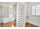 Walk-in closet with custom shelving, drawers, mirrored wall, and hardwood floors at 710 Cox Rd, Roswell, GA 30075
