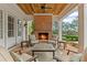 Cozy outdoor seating area with a charming brick fireplace and ceiling fan at 710 Cox Rd, Roswell, GA 30075