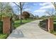 Elegant home entrance with brick columns and black wooden gate leading to a lush property at 710 Cox Rd, Roswell, GA 30075
