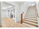 Bright entryway with light wood flooring, a staircase, and view into a living space beyond a set of glass doors at 710 Cox Rd, Roswell, GA 30075