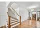Bright foyer featuring hardwood floors, a wooden staircase, and an ornate light fixture at 710 Cox Rd, Roswell, GA 30075