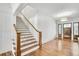 Bright foyer featuring hardwood floors, staircase with wood handrail, and entry doors at 710 Cox Rd, Roswell, GA 30075