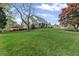 Lush green lawn surrounds a stately home, complemented by mature trees and flowering shrubs at 710 Cox Rd, Roswell, GA 30075